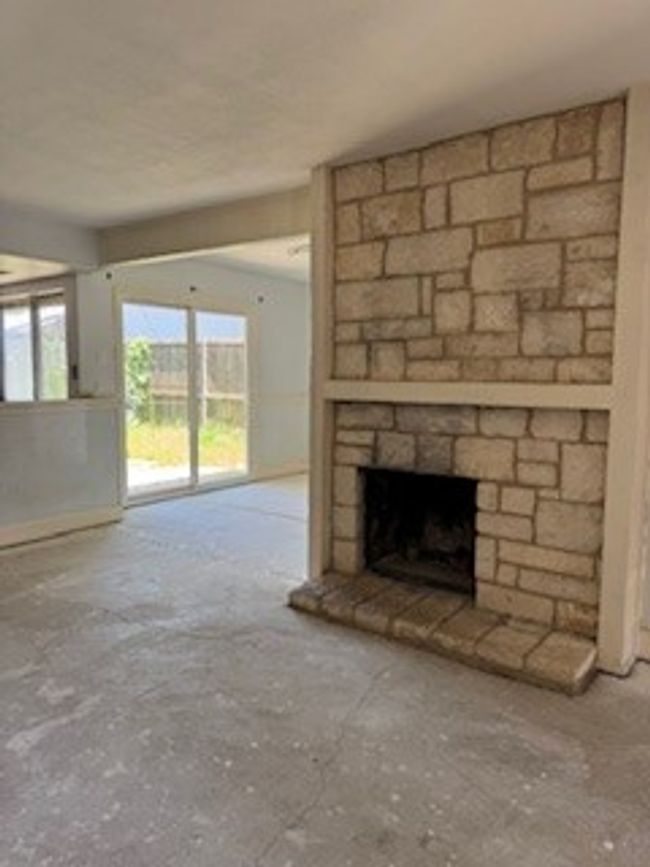 Unfurnished living room featuring a stone fireplace | Image 4