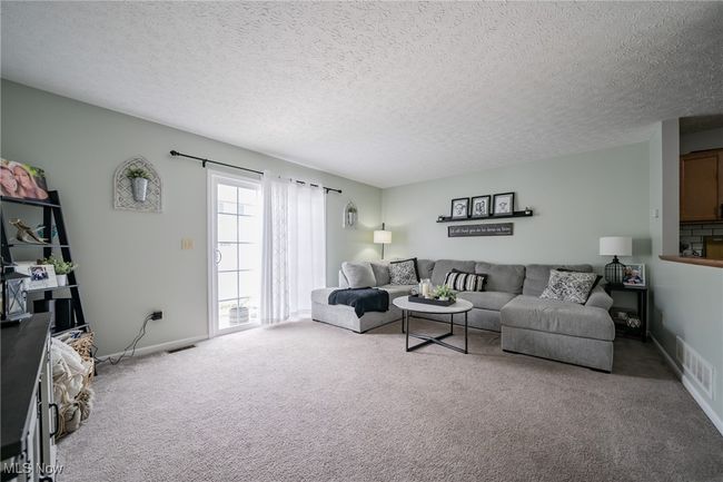 Carpeted living room featuring a textured ceiling | Image 10