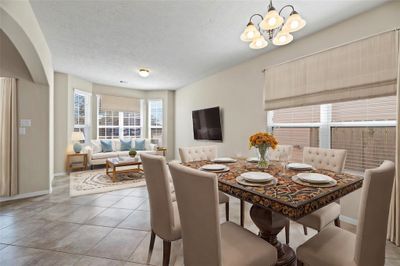 Natural lighting and neutral walls complete the stunning look of this inviting dining space and living room. The dining room opens to the entryway leading to the kitchen, making the flow for entertaining effortless. Gather here and start creating lasting memories. | Image 3