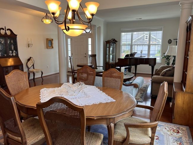 Dining room featuring ornate columns, hardwood / wood-style floors, and a notable chandelier | Image 14