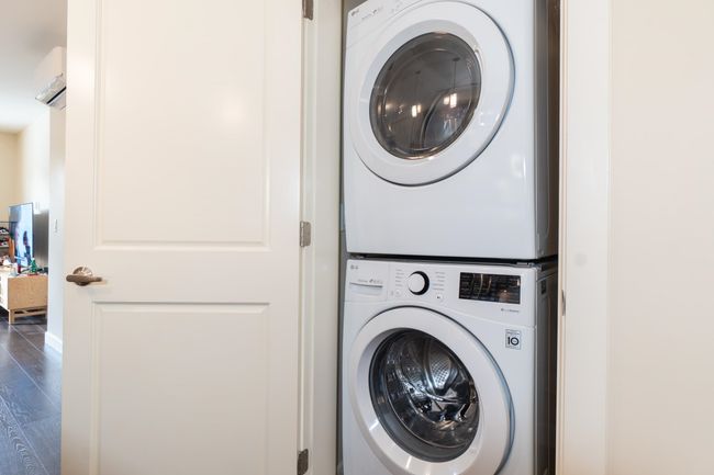 Washroom featuring stacked washer / dryer and wood finished floors | Image 28