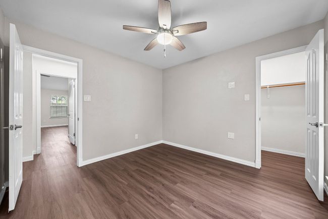 Unfurnished bedroom with dark wood finished floors, baseboards, a spacious closet, and a closet | Image 16