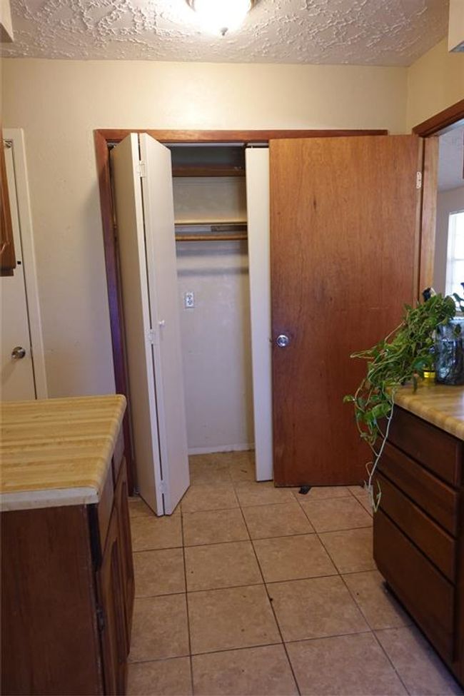 Laundry room with ample closet space, featuring tiled floors and convenient cabinetry for storage and organization. | Image 19