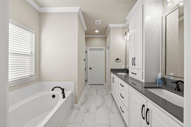 Full bathroom with a garden tub, marble finish floor, a sink, and ornamental molding | Image 12