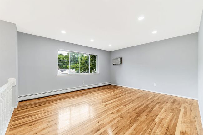 Unfurnished room with a baseboard radiator, recessed lighting, baseboards, and wood finished floors | Image 5