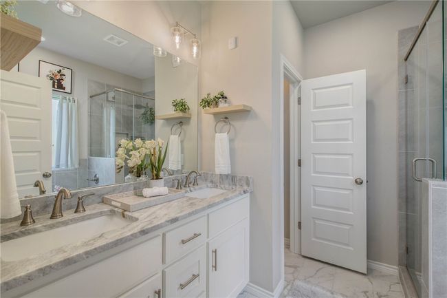 Full bathroom with double vanity, a stall shower, and marble finish floors | Image 24
