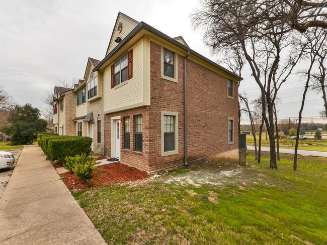 View of property exterior with brick siding and a yard | Image 6