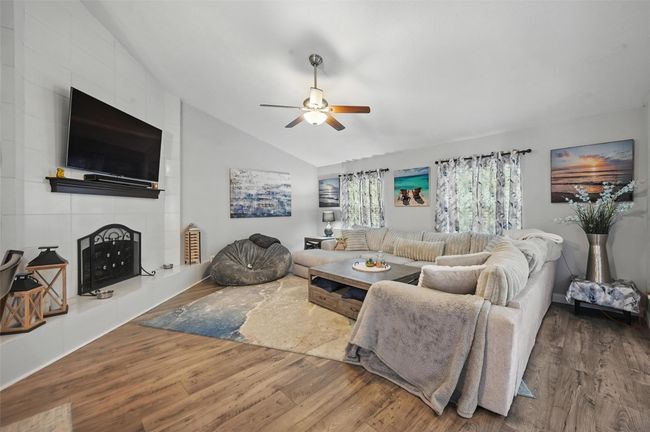 Living room featuring lofted ceiling, wood finished floors, and a ceiling fan | Image 7