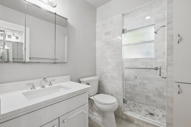 Bathroom with vanity, toilet, a stall shower, and tile patterned floors | Image 25