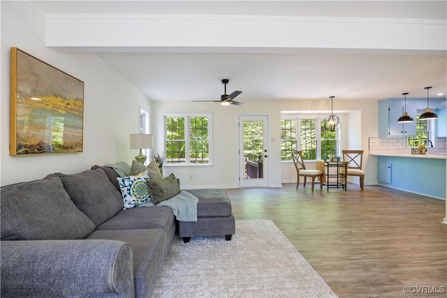 Living room with wood finished floors, beam ceiling, a ceiling fan, and baseboards | Image 11