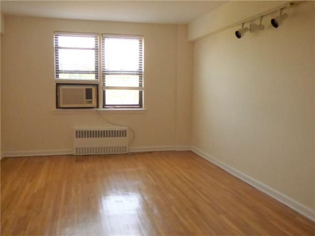 Living room featuring baseboards, radiator, cooling unit, wood finished floors, and rail lighting | Image 11