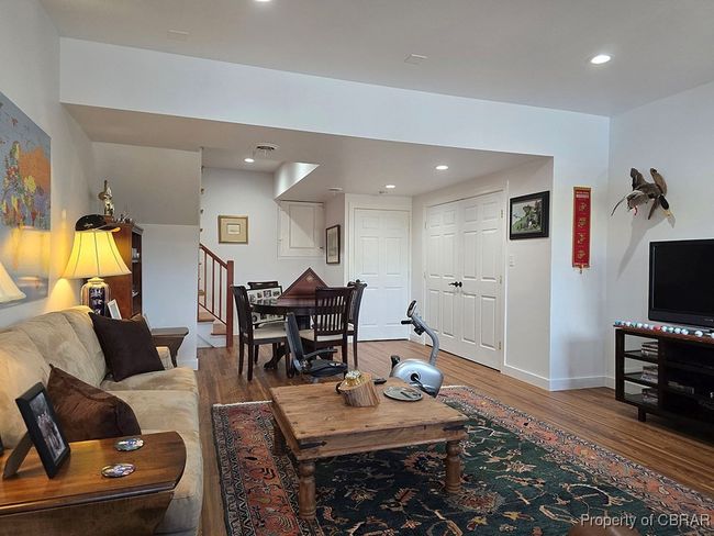 Living area featuring wood finished floors, baseboards, recessed lighting, and stairs | Image 32