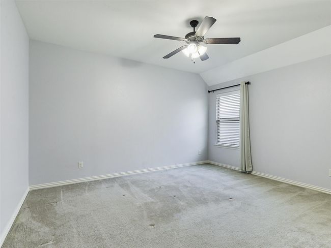 Carpeted spare room with a ceiling fan and vaulted ceiling | Image 30