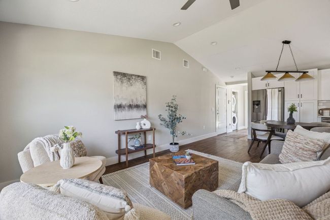 Living area featuring wood finished floors, lofted ceiling, a ceiling fan, and recessed lighting | Image 7