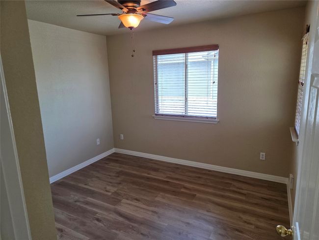 Empty room featuring dark wood finished floors and a ceiling fan | Image 21