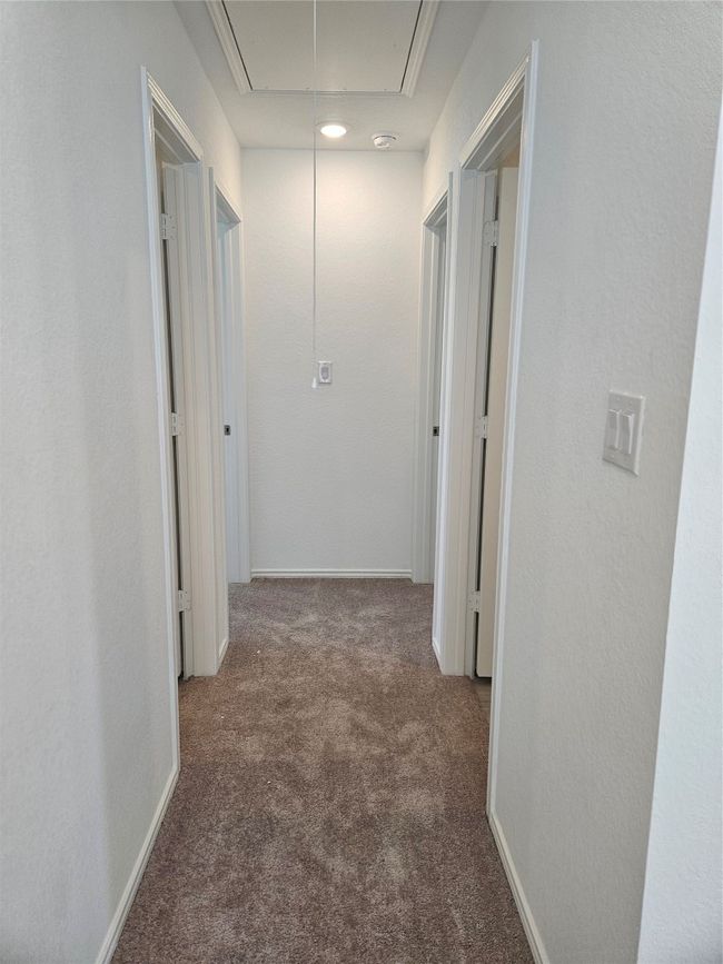 Hall featuring attic access and carpet flooring | Image 10
