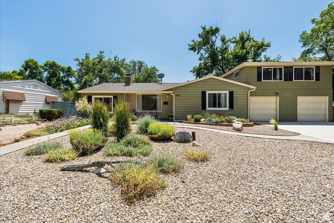 View of front of house featuring driveway, a chimney, and an attached garage | Image 5