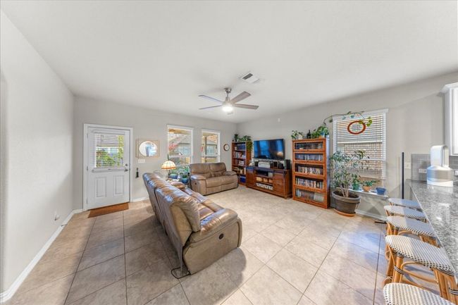 Living room featuring light tile patterned floors and a ceiling fan | Image 6