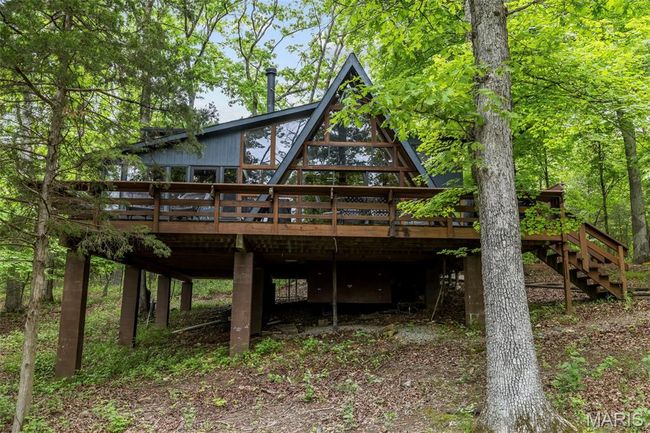 Rear view of house with a wooden deck and stairs | Image 51