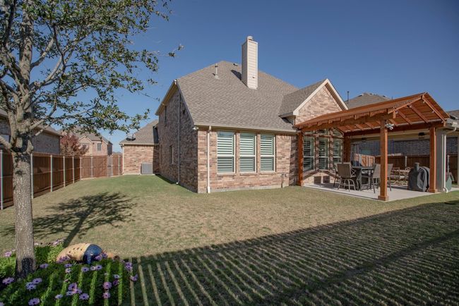 Back of property with a pergola, a fenced backyard, a patio, and a chimney | Image 35