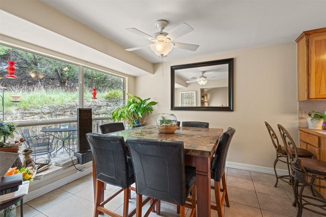 Dining area featuring light tile patterned flooring, ceiling fan, and baseboards | Image 16
