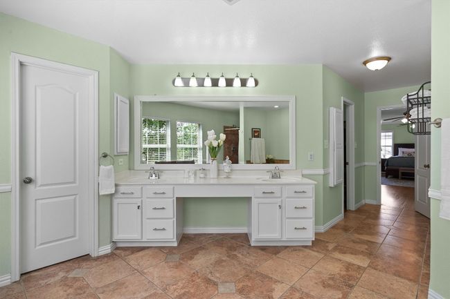 luxurious primary bath featuring double vanities, two walk-in closets, a garden tub, and a separate shower. | Image 27