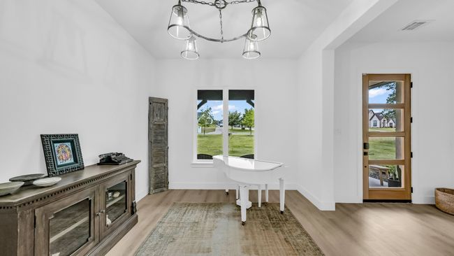Entryway with wood finished floors, healthy amount of natural light, and a chandelier | Image 6