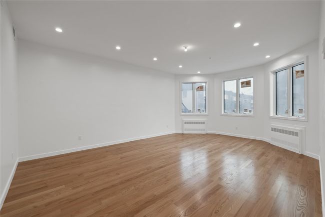 Spare room with radiator heating unit, recessed lighting, light wood-style flooring, and baseboards | Image 7