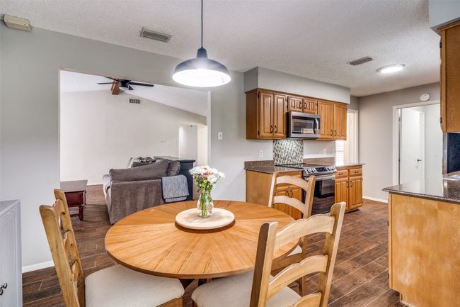 Dining room with dark wood finished floors, ceiling fan, and a textured ceiling | Image 10
