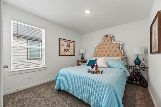 The extra bedroom features cozy carpet flooring and a generously sized window that lets in plenty of natural light. The recessed lighting in the ceiling provides a modern touch, offering well-distributed, soft illumination throughout the room. The light-colored walls enhance the feeling of openness, making the space feel bright and airy. It’s a versatile room that can easily adapt to a variety of uses, from a guest room to a home office, all while maintaining a welcoming and comfortable atmosphere. | Image 15