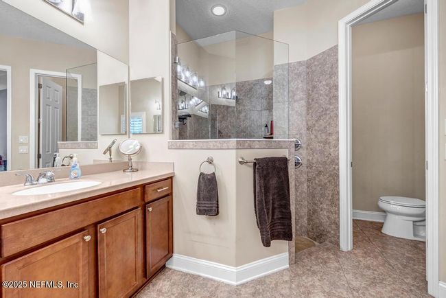 Primary bathroom with double sinks and vanity space in between | Image 34