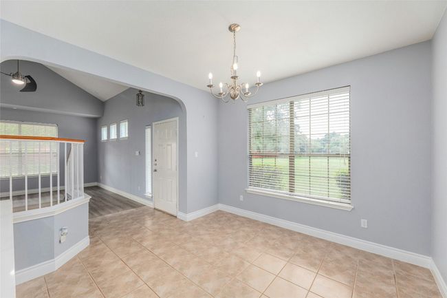 Unfurnished room featuring a chandelier, arched walkways, light tile patterned flooring, and vaulted ceiling | Image 9
