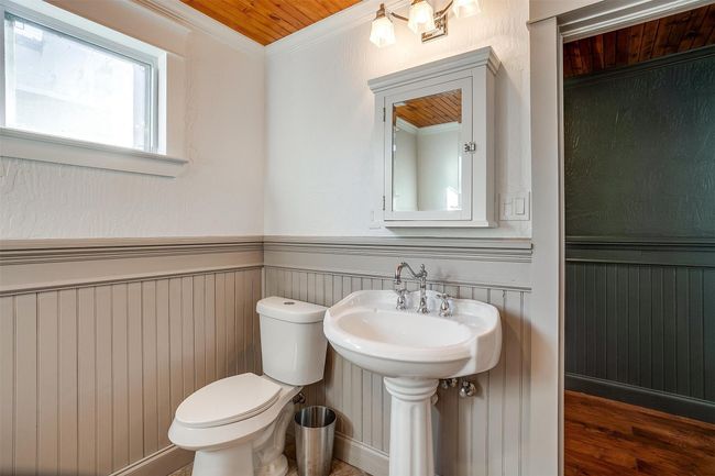 Bathroom featuring toilet, a wainscoted wall, crown molding, wooden ceiling, and wood finished floors | Image 30