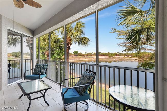 Sunroom featuring a water view, ceiling fan, and lofted ceiling | Image 17