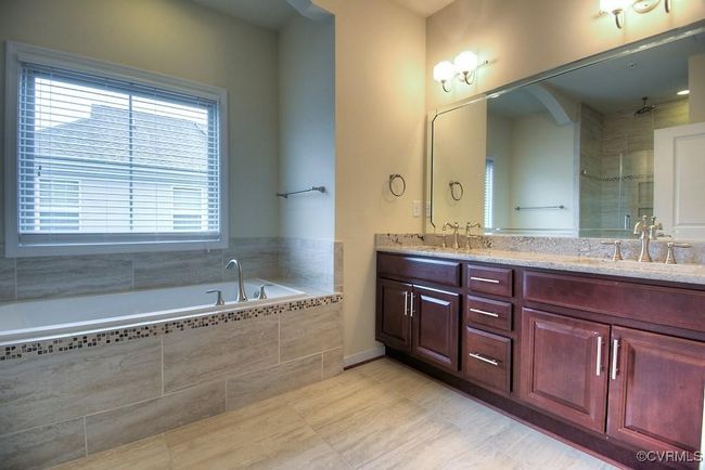 Full bathroom with double vanity, a garden tub, a stall shower, and tile patterned flooring | Image 5