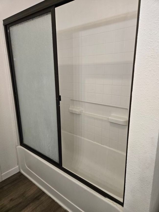 Full bathroom featuring wood finished floors and combined bath / shower with glass door | Image 14