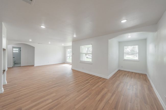 Empty room featuring arched walkways, light wood-style floors, baseboards, and recessed lighting | Image 33