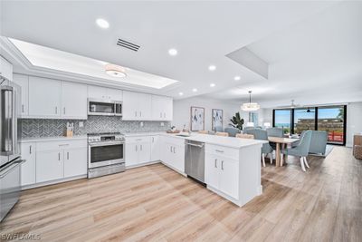 Kitchen featuring light hardwood / wood-style flooring, kitchen peninsula, and stainless steel appliances | Image 1