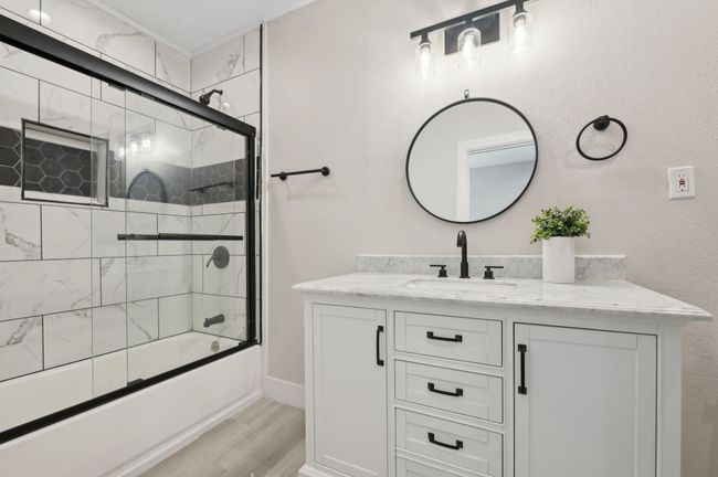 Full bath with vanity, combined bath / shower with glass door, and wood finished floors | Image 25