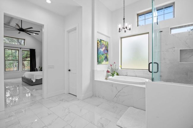 Ensuite bathroom with tile flooring, plenty of natural light, a garden tub, a chandelier, and recessed lighting | Image 16