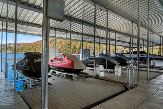 Dock area featuring boat lift and a water view | Image 63