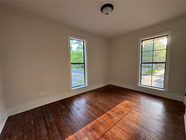 Spare room featuring baseboards, a wealth of natural light, and dark wood-style flooring | Image 9