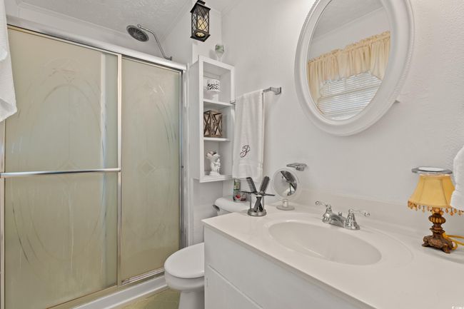 Full bath featuring crown molding, vanity, a shower stall, and toilet | Image 15