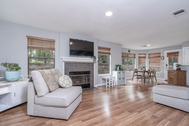 Living area featuring light wood-type flooring, visible vents, and a wealth of natural light. | Image 7