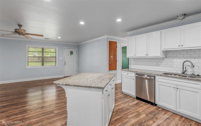 Kitchen featuring a sink, crown molding, a ceiling fan, backsplash, and dishwasher | Image 4