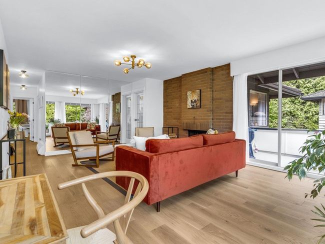Living area featuring light wood-type flooring, a chandelier, and a fireplace | Image 9