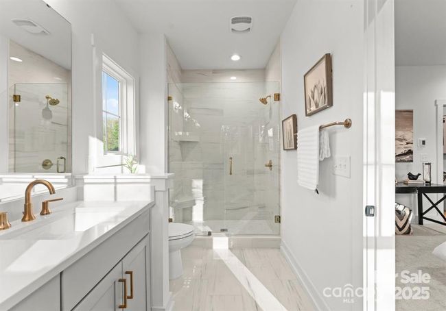 This luxurious primary bathroom showcases a spacious walk in shower with elegant finishes and a sleek double vanity featuring quartz countertops- designed for both comfort and style. | Image 16