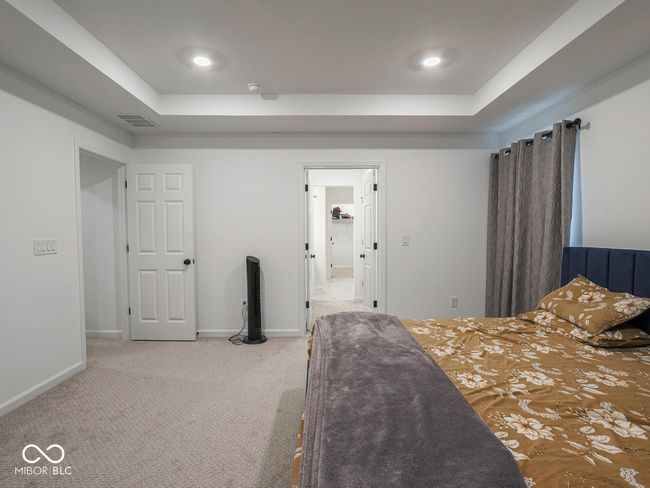 carpeted bedroom with recessed lighting, visible vents, baseboards, and a raised ceiling | Image 35