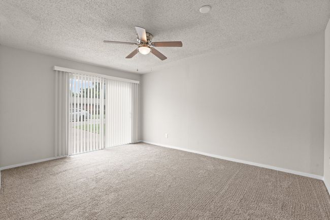 Carpeted empty room with a textured ceiling and a ceiling fan | Image 9