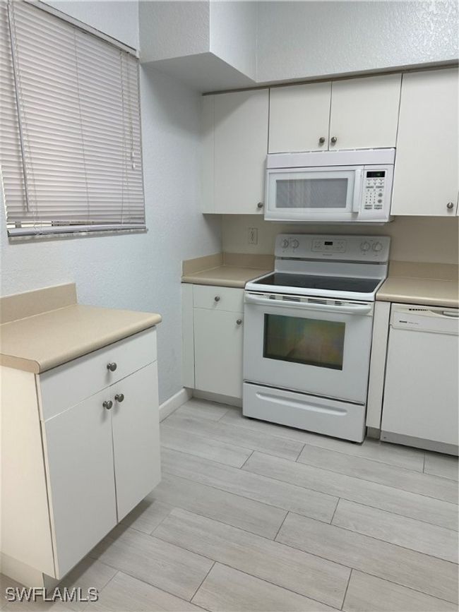 Kitchen featuring white cabinetry, white range oven, and dishwasher | Image 8